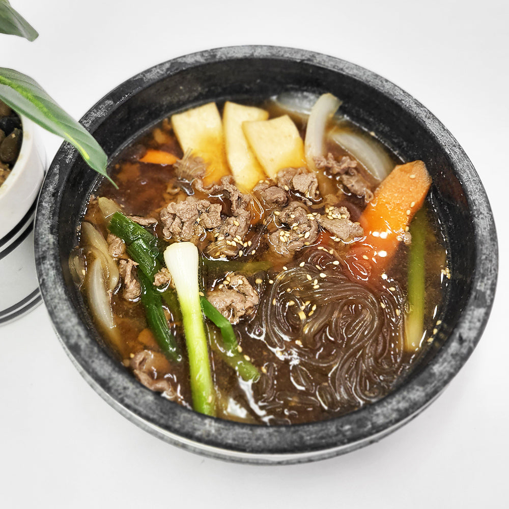 Close-up view of Ttukbaegi-bulgogi (Korean sizzling beef bulgogi in stone pot) | Banchan365