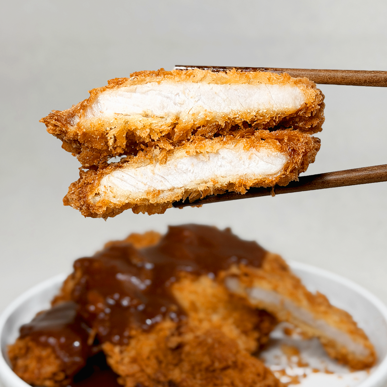 Close-up view of Tonkatsu (Korean-style thick pork cutlet) – housemade with sauce | Banchan365